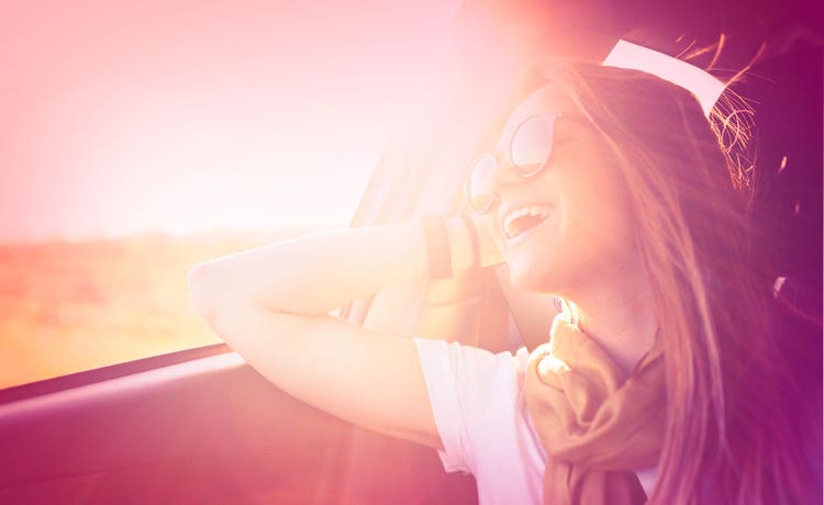 girl smiling in car because she bought a new car
