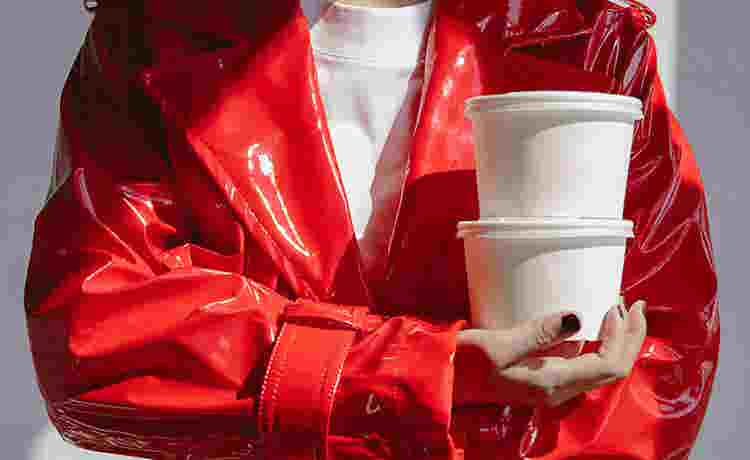 Person in red pleather coat holds two white takeaway containers that she paid for with points