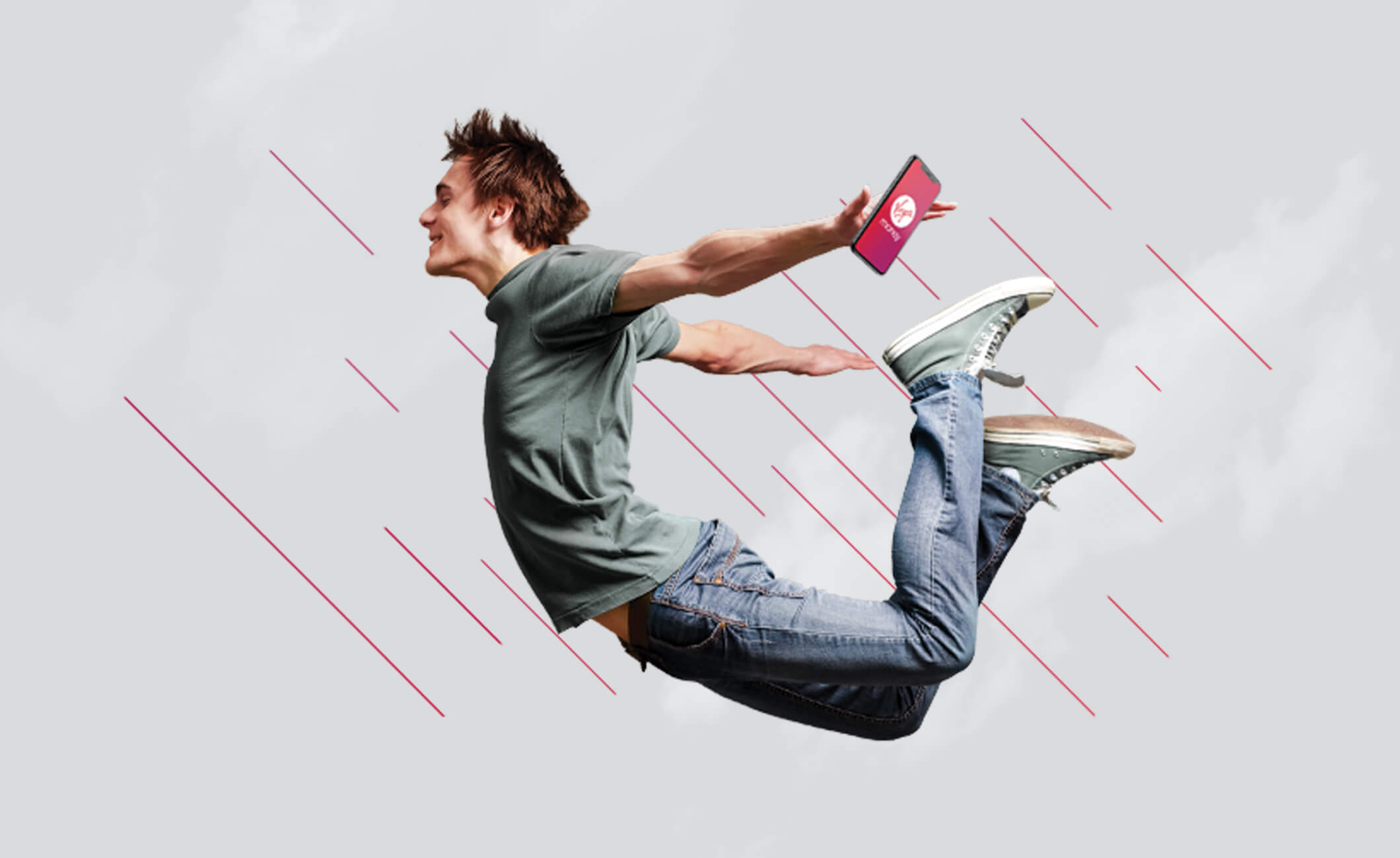 Man leaping through the air holding phone with Virgin Money app on screen