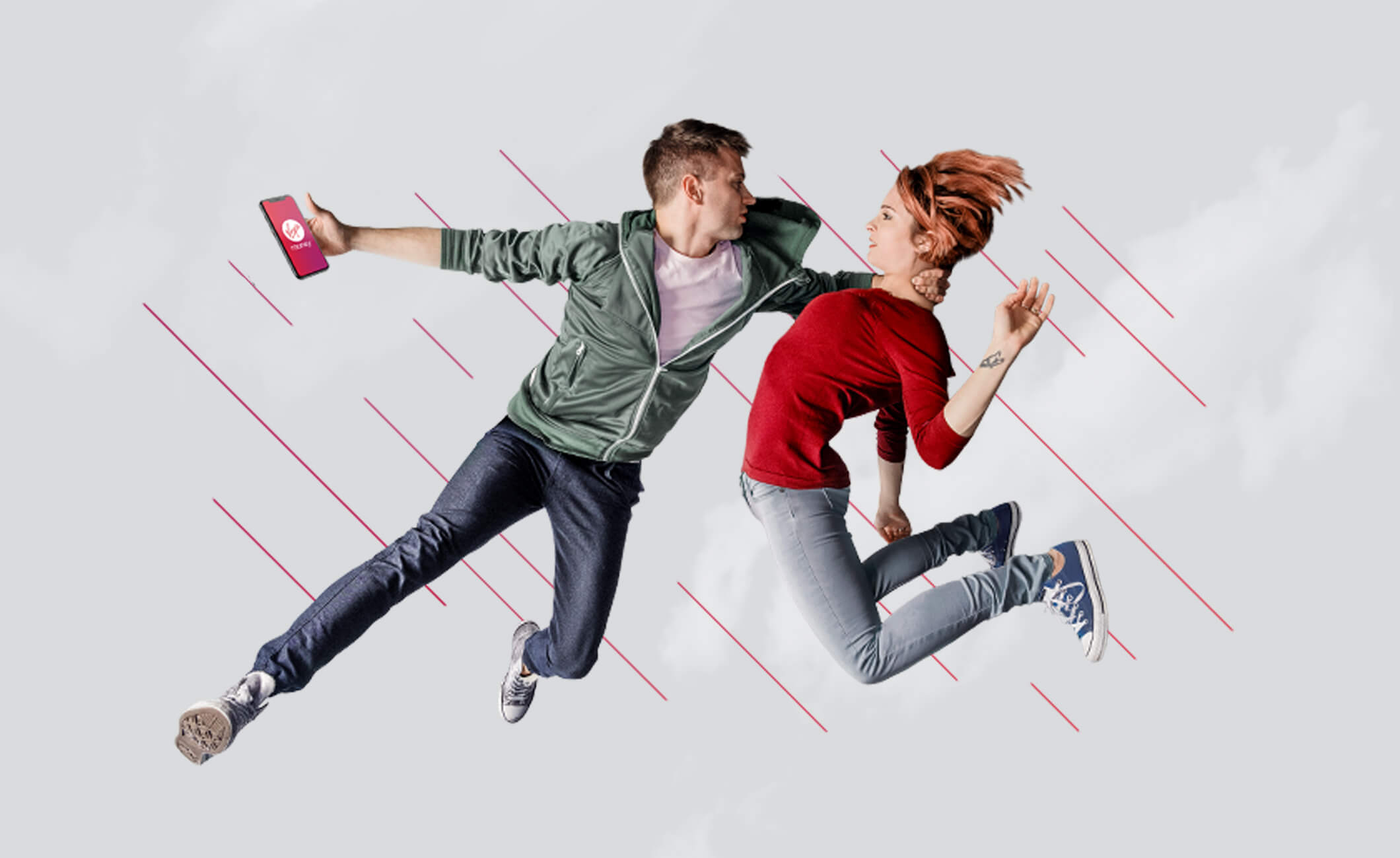 Man and woman leaping in the air, man reaching towards woman and holding phone with Virgin Money app on the screen