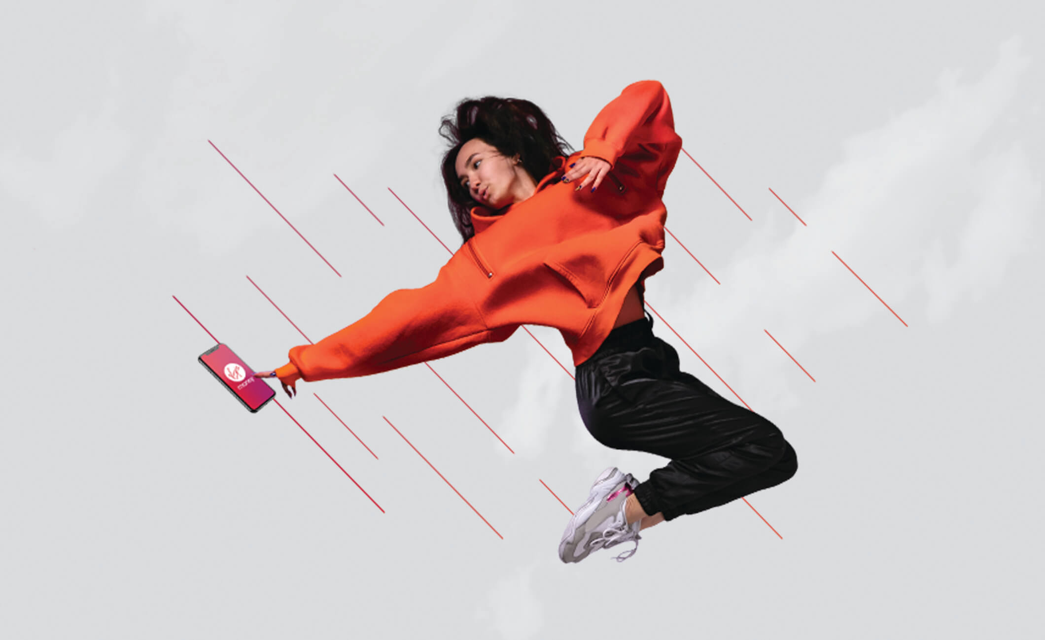 Young woman jumping and pointing at Virgin Money app on phone screen