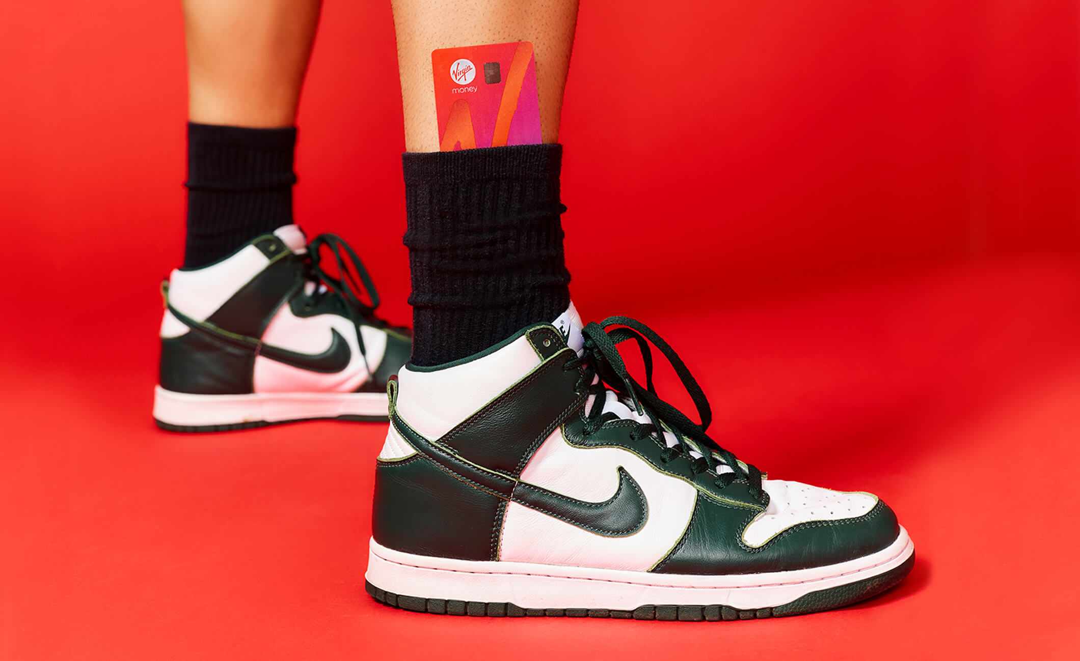 Male leg wearing Nike shoe with Virgin Money card tucked into sock.