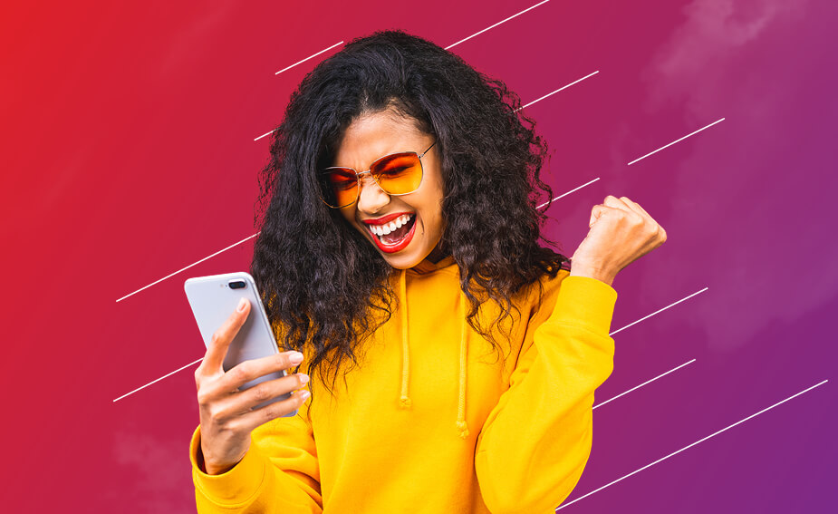 Woman in sunglasses looking at mobile phone and celebrating